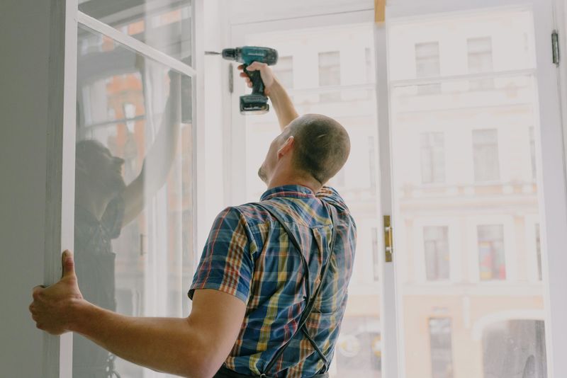 a handyman mounting a shelf on a wall with a drill